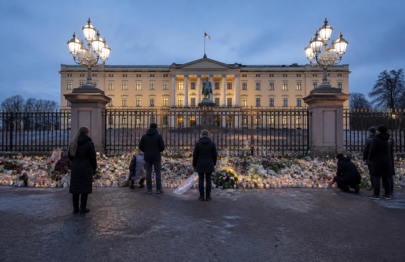 Mourners laying flowers and candles at the gates of the Royal Palace in Oslo at dusk